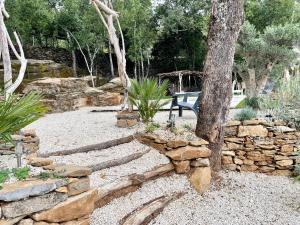 a garden with a stone wall and a tree at VILLA haut de gamme 6-8p, 3 ch, 3 sdb, piscine et superbe jardin clos in Saint-Sernin