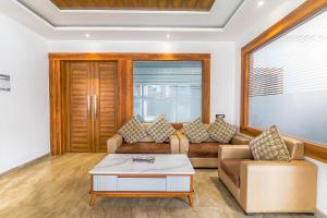 ein Wohnzimmer mit einem Sofa und einem Couchtisch in der Unterkunft FabExpress Global Inn New in Lucknow