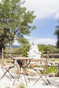 een standbeeld en een tafel en stoelen voor een standbeeld bij Boutique Hotel Rancho Los Lobos in Jimena de la Frontera