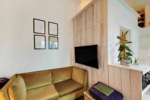ein Wohnzimmer mit einem Sofa und einem Flachbild-TV in der Unterkunft Cozy studio flat in Notting Hill in London