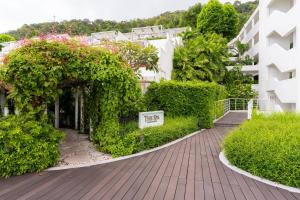 a walkway in front of a building with flowers at The Nai Harn in Nai Harn Beach