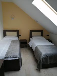 two beds in a room with a attic at VILA DE PE DEAL in Poiana Stampei
