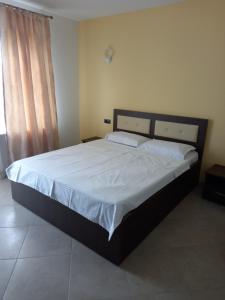 a bedroom with a large bed with white sheets at VILA DE PE DEAL in Poiana Stampei