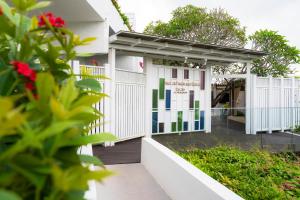 a white building with a gate and flowers at The Nai Harn in Nai Harn Beach