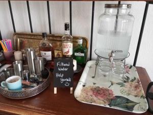 een houten tafel met flessen alcohol en een dienblad met eten bij Garway Lodge Guest House in Torquay
