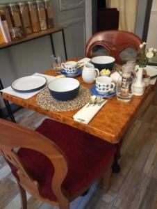 a wooden table with bowls and plates on it at Garway Lodge Guest House in Torquay