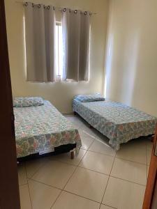 a room with two beds and a window at Apartamento Centro Alfenas in Alfenas