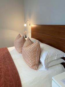 a bed with four pillows on top of it at Belgravia Apartments in London