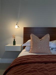 a bedroom with a bed with a pillow and a lamp at Belgravia Apartments in London