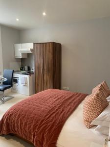 a bedroom with a large bed and a kitchen at Belgravia Apartments in London