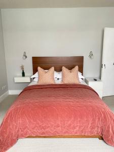 a bedroom with a large red bed with pillows at Belgravia Apartments in London