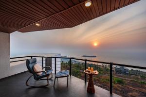 a room with a balcony with a view of the ocean at SaffronStays Mimosa Sunsets in Dapoli