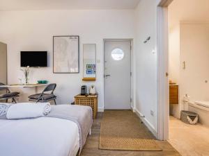 Un dormitorio con una cama, un escritorio y una mesa. en Pass the Keys Delightful Studio in West Ashling, en Chichester