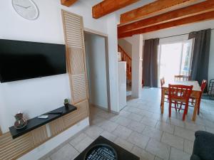 a living room with a flat screen tv on a wall at La Cour des Miracles in Vallon-Pont-dʼArc