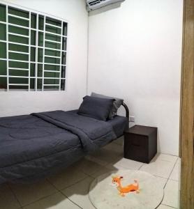Un dormitorio con una cama y un caballo de juguete sobre una alfombra en Homestay @Seri Sindang Guesthouse en Kota Samarahan