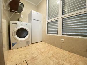 a laundry room with a washing machine and a window at Luz's Retreat Apartment in Ponta Delgada