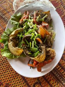 einen Teller Essen mit Salat auf dem Tisch in der Unterkunft River Park in Kampot