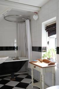 baño con bañera negra y lavamanos en Badger Cottage at Alde Garden en Saxmundham