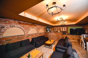 a living room with couches and a brick wall at Rönkház Noszvaj in Noszvaj