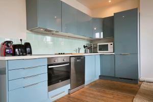 eine Küche mit Küchengeräten aus Edelstahl und blauen Schränken in der Unterkunft Lille hypercentre-2 bedrooms very bright + parking in Lille