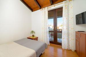 a bedroom with a bed and a sliding glass door at Apartment Pinjola in Poreč