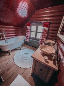 a bathroom with a tub and a sink in a cabin at Rönkház Noszvaj in Noszvaj