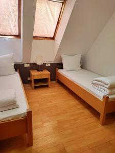 2 Betten in einem kleinen Zimmer mit Fenster in der Unterkunft Villa Mari I in Maribor