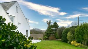 a white house with a yard with green grass at Ty Draw in Abersoch