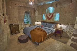 een slaapkamer met een bed in een stenen kamer bij Sirius Cave Cappadocia in Urgup