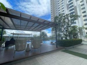 a wooden deck with chairs and a pergola at 42nd Floor Condo with Pool at Horizon 101 Tower 2 in Cebu City