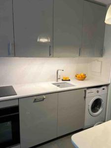 een keuken met een wastafel en een wasmachine bij Élégant appartement quartierde la Bastille in Parijs