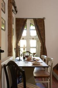un tavolo da pranzo con sedie e una finestra di Badger Cottage at Alde Garden a Saxmundham