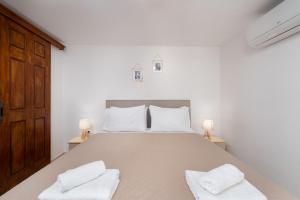 - une chambre avec un grand lit et 2 serviettes blanches dans l'établissement Plethora Homes, à Kamari