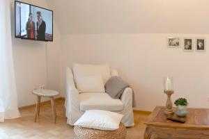uma sala de estar com uma cadeira e uma televisão na parede em Ferienwohnung am Hafen Bad Bevensen em Bad Bevensen