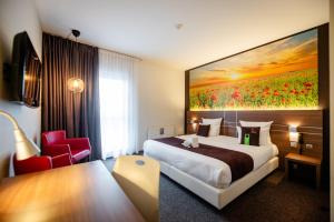 a hotel room with a bed and a painting on the wall at Hotel-Restaurant Horizon Ath-Lessines in Ghislenghien +81 photos