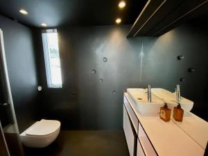 a bathroom with a white sink and a toilet at Oceanview Mini-House - Stunning Views in Ramberg +74 photos