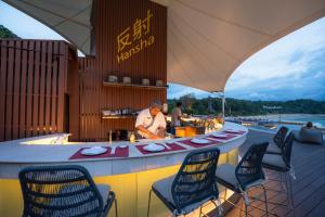 a bar with chairs and a chef preparing food at The Nai Harn in Nai Harn Beach