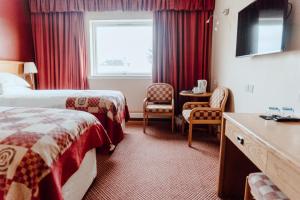 a hotel room with two beds and a window at Cabarfeidh Hotel in Stornoway