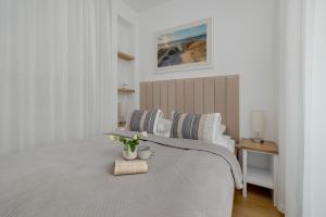 Un dormitorio blanco con una cama con flores. en Baltic Marina Residence Studios with Balcony & Pet Friendly by Renters en Kołobrzeg