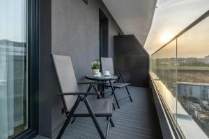 balcón con mesa, sillas y ventana en Baltic Marina Residence Studios with Balcony & Pet Friendly by Renters en Kołobrzeg