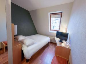 a small bedroom with a bed and a television at ibis Saint Quentin Basilique in Saint-Quentin