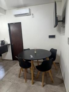 Un comedor con una mesa y sillas negras. en SURI, en Salta 4 fotos más
