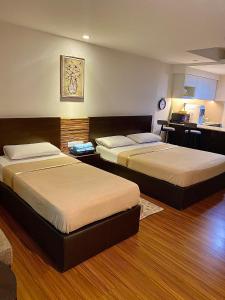 een hotelkamer met 2 bedden en een keuken bij Ain Studio Apartment in Kota Bharu