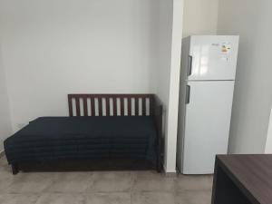1 dormitorio con 1 cama junto a una nevera en SURI, en Salta