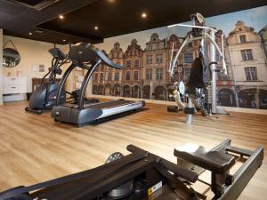 a gym with two tread machines and a wall mural at Mercure Arras Centre Gare in Arras