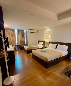 Habitación de hotel con 2 camas y sofá en Ain Studio Apartment, en Kota Bharu