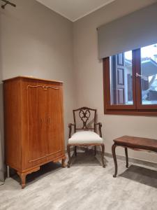 a room with a chair and a cabinet and a window at Castle luxury home in Chios