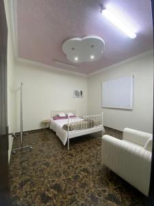 um quarto com uma cama e um sofá branco em شقة غرفتين نوم و دورة مياه و صاله كبيره ومطبخ حي الرمال بالرياض em Riyadh