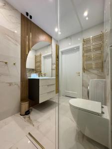 La salle de bains est pourvue d'une baignoire, d'un lavabo et de toilettes. dans l'établissement Apartament Magdy Stachuli, à Jelenia Góra