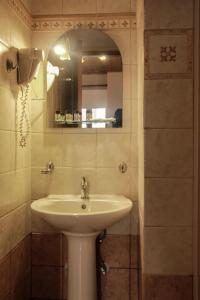 y baño con lavabo y espejo. en Guesthouse Νεδα, en Stemnitsa
